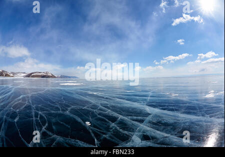 Wide angle shot of winter ice landscape on Siberian lake Baikal with dramatic weather clouds on blue sky background Stock Photo