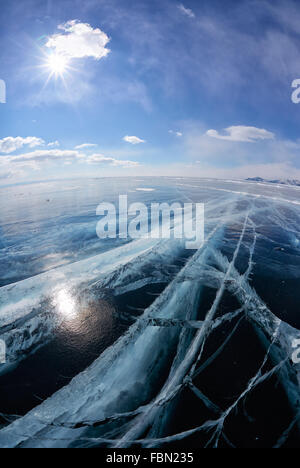 Wide angle shot of winter ice landscape on Siberian lake Baikal with dramatic weather clouds on blue sky background Stock Photo