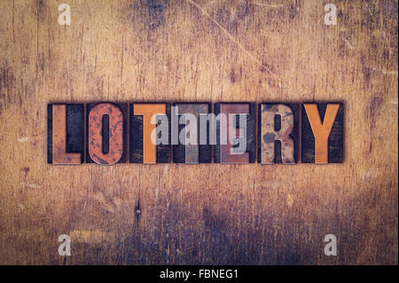 The word 'Lottery' written in dirty vintage letterpress type on a aged wooden background. Stock Photo