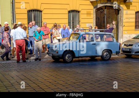TOURISTS AND TRABANT CAR BUDAPEST HUNGARY. CAR PARKED IN STREET Stock Photo