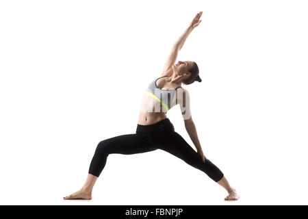 Portrait of sporty beautiful young brunette woman in sportswear bra and black pants working out, doing Reverse Warrior Pose Stock Photo