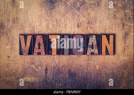 The word 'Vatican' written in dirty vintage letterpress type on a aged wooden background. Stock Photo