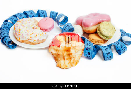 new diet concept, question sign in shape of measurment tape between red apple and donut isolated on white Stock Photo