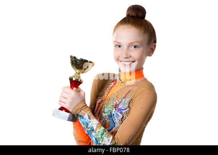 Portrait of beautiful young champion, redheaded happy smiling fit athlete teenage girl wearing dancer orange leotard posing Stock Photo