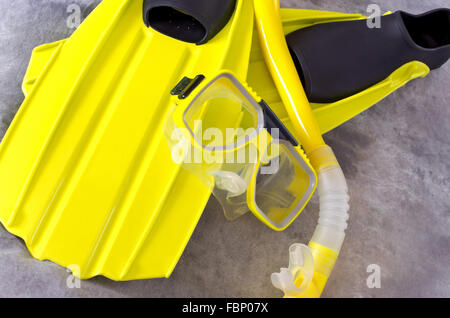 yellow snorkel mask and fins snorkeling gear isolated against gray background Stock Photo