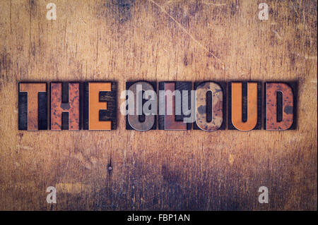 The word "The Cloud" written in dirty vintage letterpress type on a aged wooden background. Stock Photo