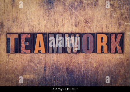 The word "Teamwork" written in dirty vintage letterpress type on a aged wooden background. Stock Photo