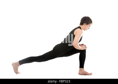 Profile of sporty young man warming up, stretching, standing in high lunge exercise, Equestrian yoga pose, Ashwa Sanchalanasana Stock Photo