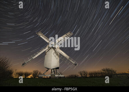 Chillenden windmill in Kent England lit by the moon with star trails above. Stock Photo