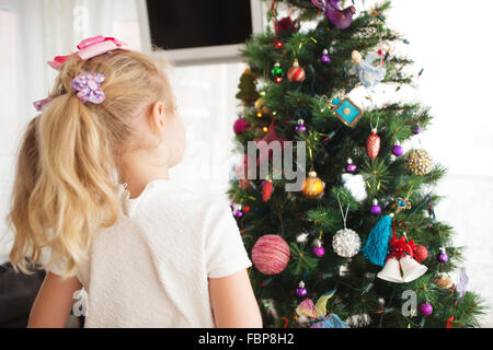 Little girl decorating Christmas tree before new year's eve. Stock Photo