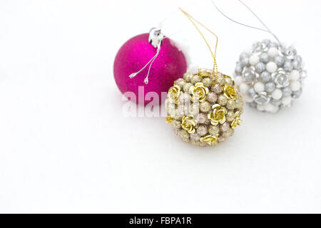 Three decorated christmas balls in the real snow. Winter outdoor Stock Photo
