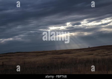 Sun rays breaking through clouds across the plains Stock Photo
