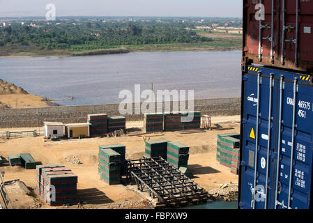 View from container ship of building materials on construction site stacked alongside the waterway of the Suez Canal Stock Photo