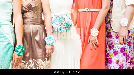 The bride and bridesmaids are showing beautiful flowers on their hands Stock Photo