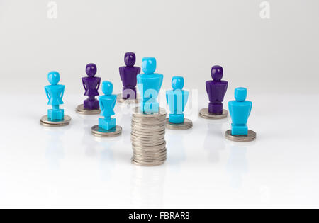 Wage gap and unequal money distribution concept shown with male and female figurines standing on coin piles Stock Photo