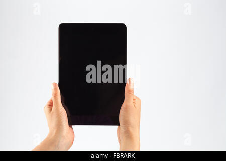 Female hands holding a tablet in vertical orientation. Isolated on white with black screen. Stock Photo