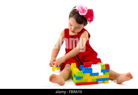 funny child girl playing with construction set over white background Stock Photo