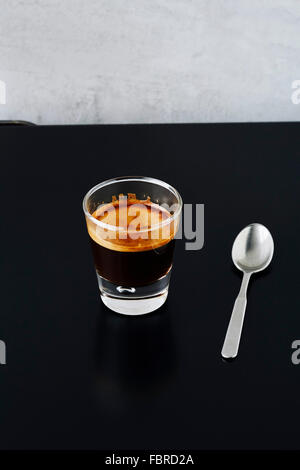 Close-up of a shot of espresso on black metal table