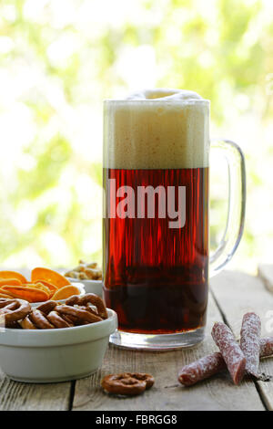 different salted snacks and a glass of fresh beer, rustic still life Stock Photo