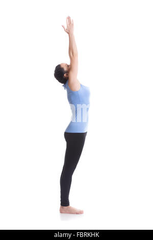 Sporty girl on white background performing Urdhva Hastasana, Upward Hand Yoga Pose, asana from Surya Namaskar sequence Stock Photo