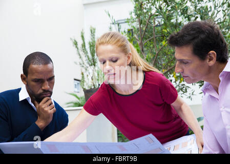 Engineer presenting blueprint to colleagues Stock Photo