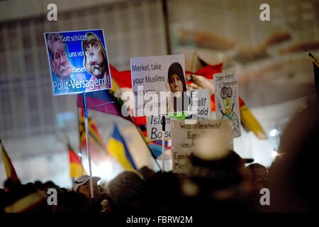 Dresden, Germany. 18th Jan, 2016. Demonstrators hold up a sign depicting German Chancellor Angela Merkel and German President Joachim Gauck that reads 'God save us from these politics failures' among others during a rally of the far-right Pegida (Patriotic Europeans against the Islamization of the Occident) movement in front of the Frauenkirche church in Dresden, Germany, 18 January 2016. Photo: ARNO BURGI/dpa/Alamy Live News Stock Photo