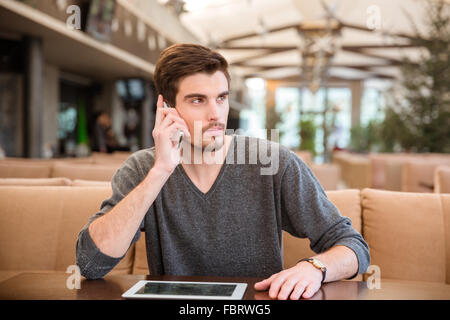 Portrait of a young man talking on the phone in restaurant Stock Photo