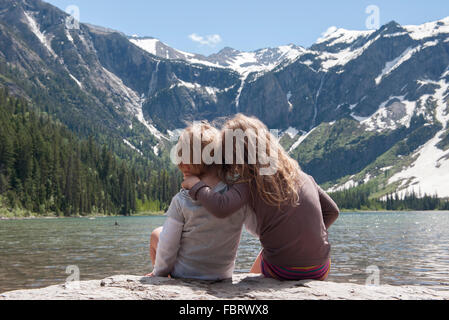 Young siblings enjoying view of mountains in Glacier National Park, Montana, USA Stock Photo
