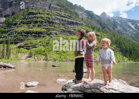 Children playing on rock in Glacier National Park, Montana, USA Stock Photo