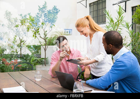 Businesswoman using digital tablet to present ideas to team members Stock Photo