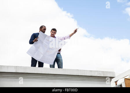Engineer showing colleague development plan Stock Photo