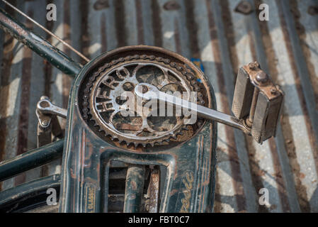 Close up study of a bicycle chain and front cassette.  Hero brand name. Pedals and frame worn and muddy. River ferry to Majuli Stock Photo