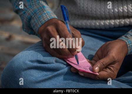 Indian men pass the time on the ferry crossing playing card games. Keeping score. Crossing the Brahmaputra River, Assam India Stock Photo