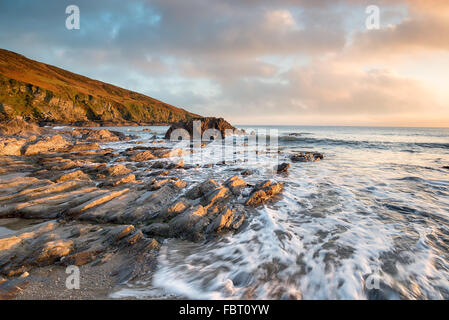 Sunset over the rocky beach at Hemmick on the south coast of Cornwall Stock Photo