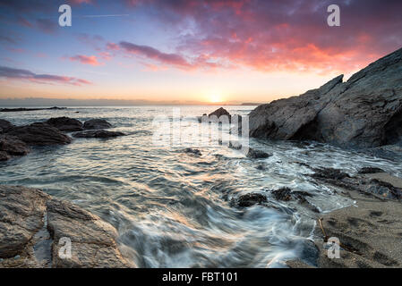 Sunset over rocks on Hemmick Beach on the south coast of Cornwall Stock Photo