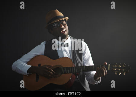 African young man playing guitar and singing Stock Photo