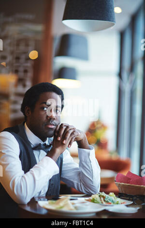 Elegant young man sitting in cafe Stock Photo