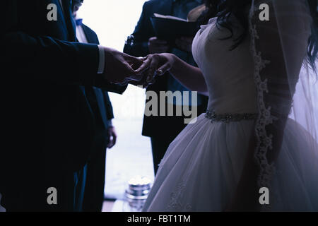 groom wears the ring bride Stock Photo