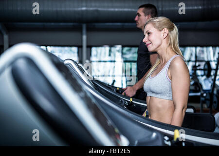 Fit smiling couple using treadmill Stock Photo