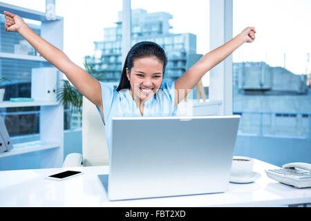 Celebrating woman with arms raised Stock Photo