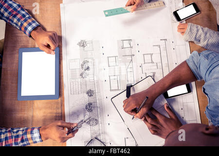 Overhead view of creative team working on desk Stock Photo