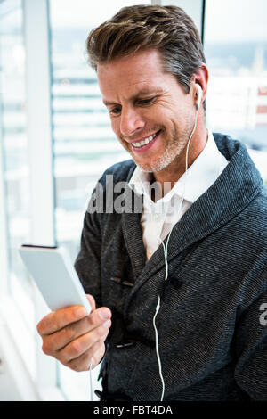 Man wearing headphones using mobile phone Stock Photo
