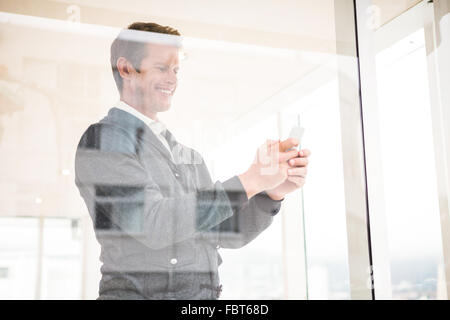 Cheerful man using mobile phone at office Stock Photo