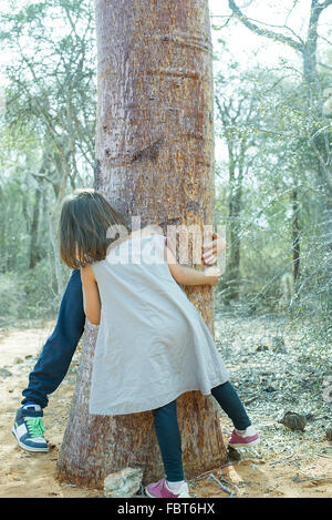 Children playing hide-and-seek in woods Stock Photo