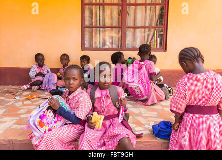 Lunch break for black infant children at a charity run school in the back streets of Kololi Gambia Stock Photo