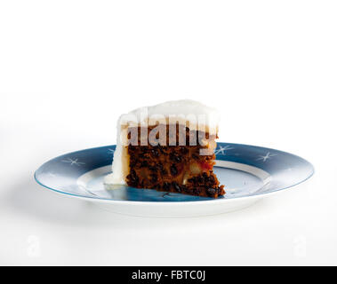 Triangular slice of traditional christmas cake on a blue starry plate Stock Photo