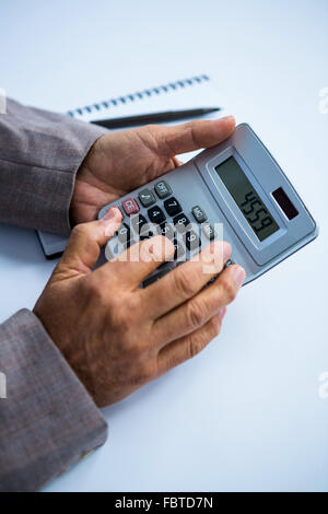 Businessman holding and using calculator Stock Photo