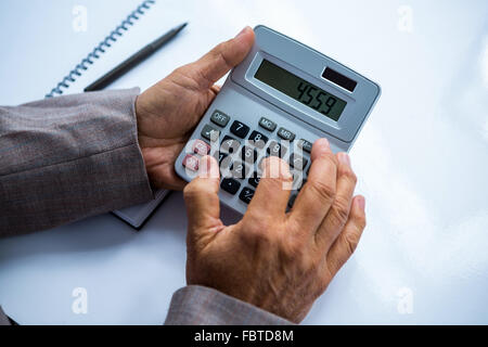 Businessman holding and using calculator Stock Photo