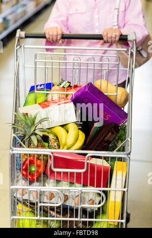 Senior woman pushing full cart Stock Photo