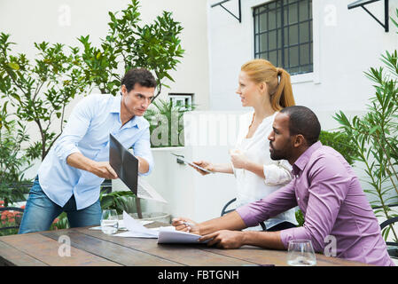 Businessman sharing good news with colleagues Stock Photo